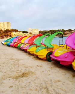 Multi colored umbrellas on beach against sky