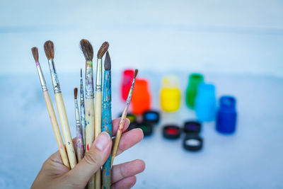 Close-up of hand holding multi colored pencils