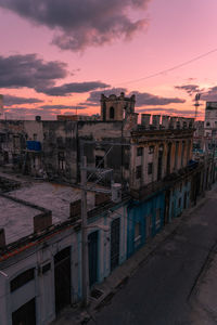 Buildings in city against sky at sunset