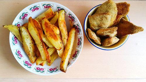 Directly above shot of breaded chicken and french fries on table