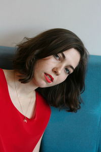 Close-up portrait of young woman against gray background