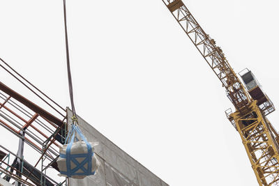 Low angle view of crane against clear sky