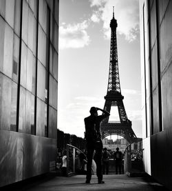 Rear view of man photographing eiffel tower in city