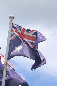 Low angle view of flag flags against sky