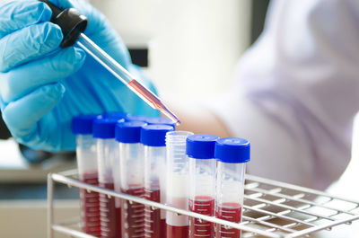 Midsection of scientist performing experiment in laboratory