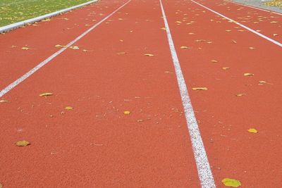 Red running track on athletic stadium in fall. concept of finished athletics season