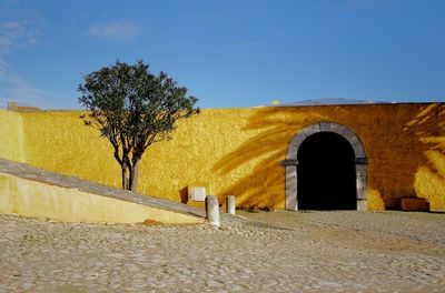 Built structure by trees against clear sky