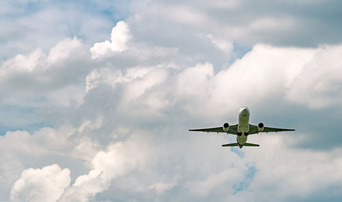 Airplane flying on sky and white fluffy cloud. commercial airline. aviation business crisis.