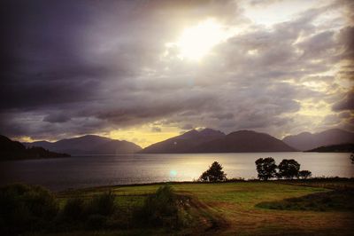 Scenic view of sea and mountains against sky during sunset