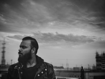 Portrait of man looking away against sky