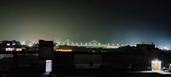 Illuminated buildings against sky at night