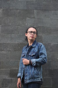 Young man standing against wall