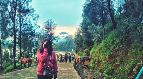 Rear view of women walking on mountain against sky