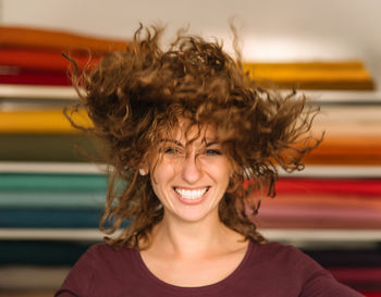 Energetic young woman with curly hair having fun in a fabric store