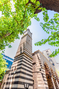 Low angle view of trees and buildings against sky