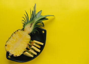 Close-up of banana on table against yellow background