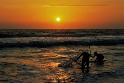 Scenic view of fisherman at sunset