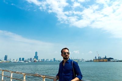 Portrait of man in city against sky