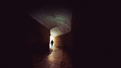 Rear view of man walking in tunnel