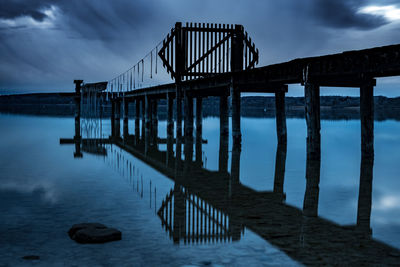 Pier over sea against sky at dusk