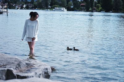 Full length of young woman with dog in lake