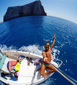 High angle view of man taking selfie in boat on sea against sky