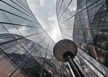 Low angle view of glass building against sky