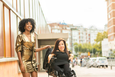 Smiling woman with handicapped friend in city