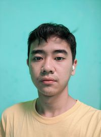 Portrait of young man against blue background