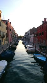 Boats in canal along buildings