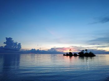 Silhouette boats in sea against sunset sky