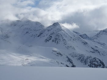 Scenic view of snow covered mountains against sky