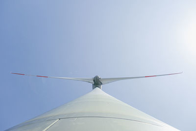 Low angle view of wind turbine against blue sky