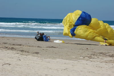 Rear view of man on beach against sky