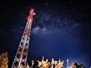 Low angle view of illuminated tower against sky at night