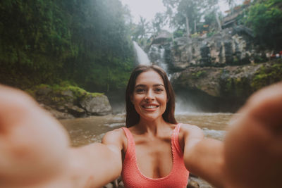 Young woman against waterfall