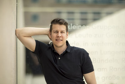 Close-up portrait of mature man standing against wall