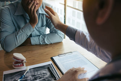 Midsection of man and woman sitting on table