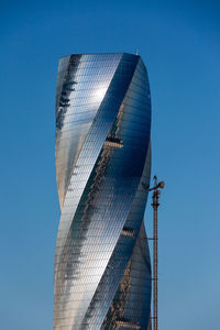 Low angle view of modern buildings against blue sky