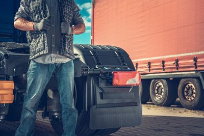 Midsection of worker standing by truck