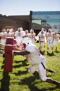 Football team practicing on grassy field