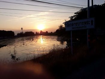 Scenic view of river against sky at sunset