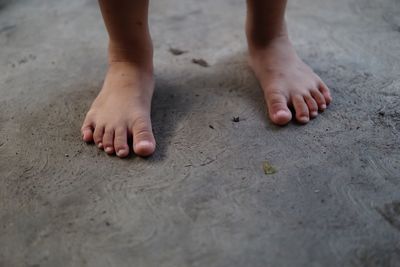 Low section of child standing on footpath