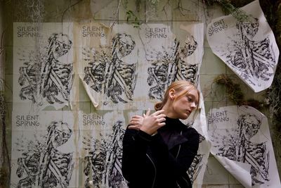 Portrait of young woman against wall