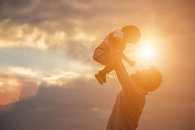 Side view of silhouette woman against orange sky