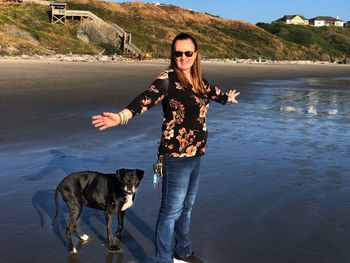 Portrait of young woman with dog at beach