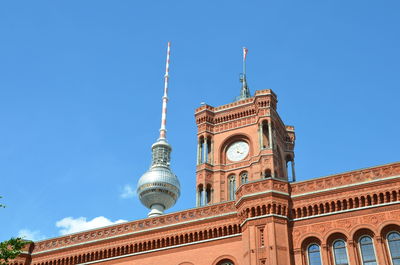 Low angle view of rotes rathaus and fernsehturm against clear blue sky