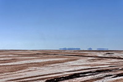 Scenic view of desert against clear blue sky