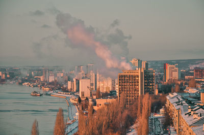 High angle view of buildings by city against sky