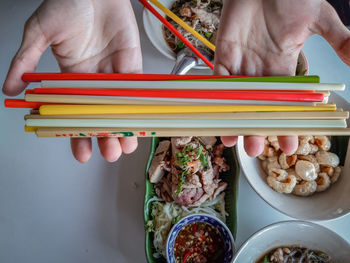 Midsection of man holding pencils on table